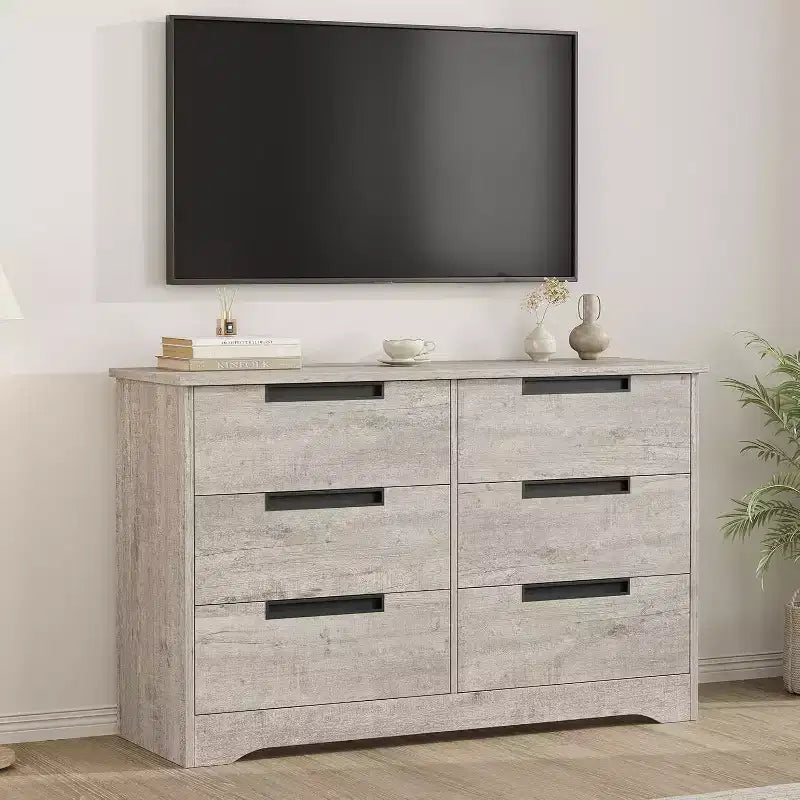 Commode six tiroirs à poignées intégrées, une unité de rangement compacte et peu encombrante, idéale pour les salons et les couloirs.